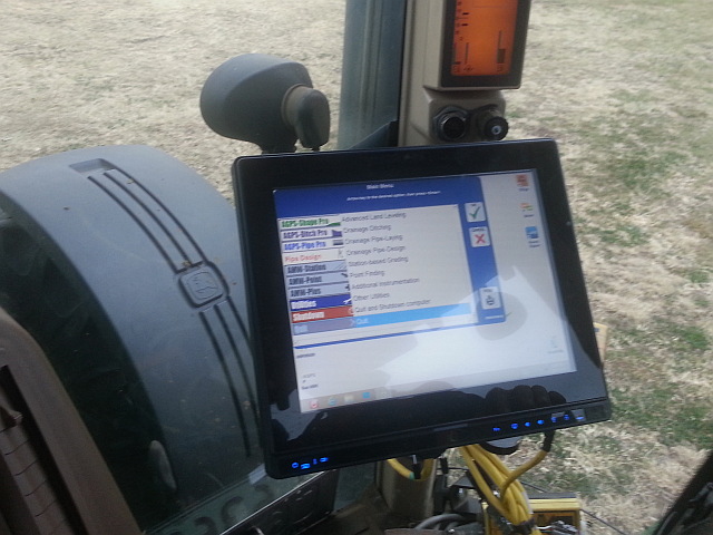 AGPSInc unit installed in tractor surveys topography and guides equipment for land levelling, ditch digging and pipe laying
